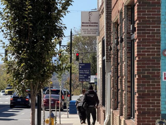 Pedestrians walk past Western Carolina Rescue Ministries in downtown Asheville.